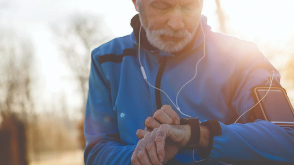 A man checking their smart watch while exercising and listening to music.
