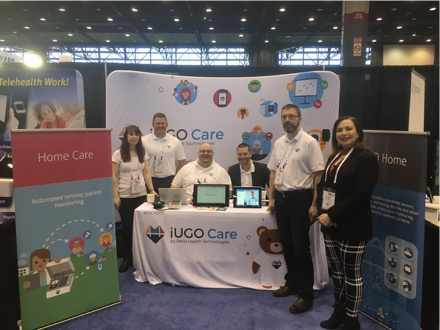 iUGO Care employees at a booth during a convention.
